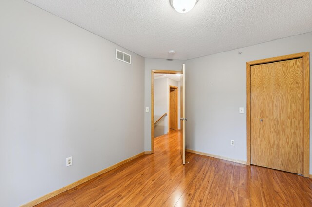 18267 Coneflower Ln, Eden Prairie, MN 55346 - unfurnished bedroom featuring a textured ceiling and light wood finished floors
