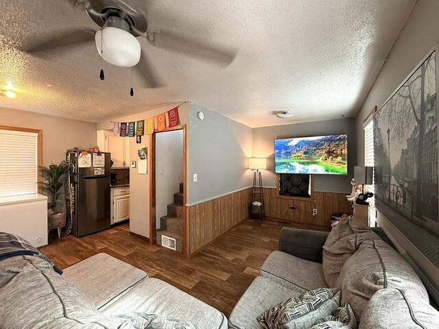 835 9th Ave, Granite Falls, MN 56241 - living area with dark wood-style flooring, a textured ceiling, wainscoting, a ceiling fan, and wooden walls