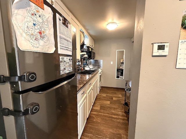 835 9th Ave, Granite Falls, MN 56241 - kitchen with freestanding refrigerator, dark wood finished floors, dark countertops, and cream cabinets