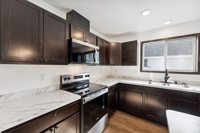 1094 7th St E, Saint Paul, MN 55106 - kitchen featuring appliances with stainless steel finishes, light wood-style floors, dark brown cabinets, and recessed lighting