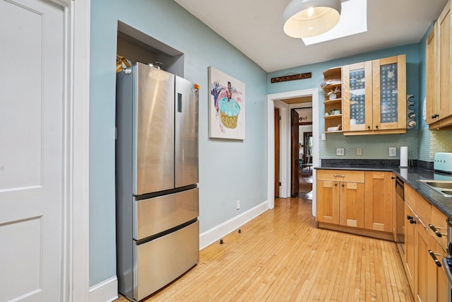 1718 Clinton Ave Unit 6, Minneapolis, MN 55404 - kitchen with freestanding refrigerator, dark countertops, tasteful backsplash, light wood-type flooring, and open shelves