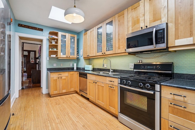 1718 Clinton Ave Unit 6, Minneapolis, MN 55404 - kitchen featuring stainless steel appliances, light wood-style flooring, dark countertops, and decorative backsplash