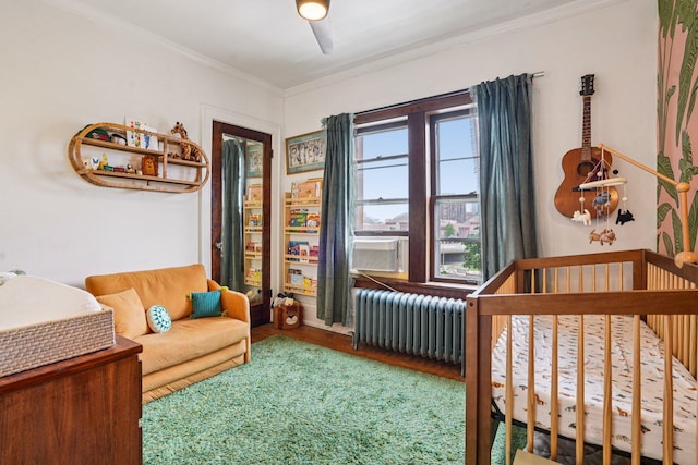 1718 Clinton Ave Unit 6, Minneapolis, MN 55404 - bedroom with radiator, wood finished floors, a crib, ornamental molding, and multiple windows