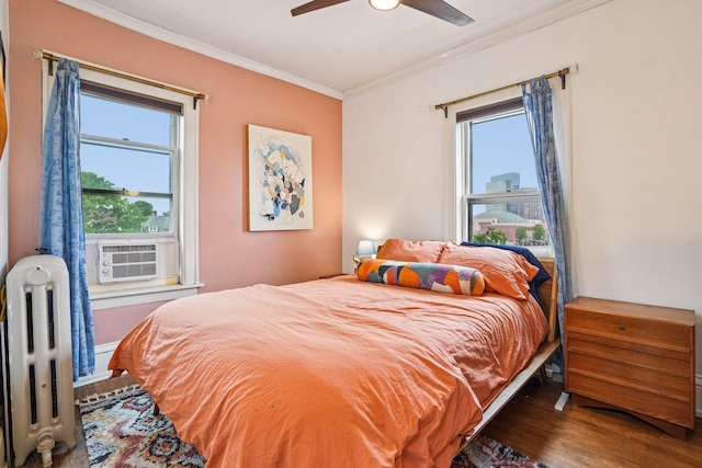 1718 Clinton Ave Unit 6, Minneapolis, MN 55404 - bedroom featuring radiator heating unit, ornamental molding, wood finished floors, cooling unit, and multiple windows
