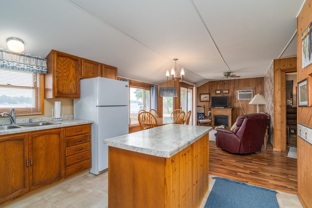 13506 Elmer Hanson Dr SE, Woodside Twp, MN 56736 - kitchen with freestanding refrigerator, wooden walls, ceiling fan, brown cabinets, and light countertops