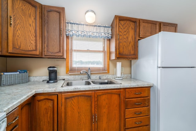13506 Elmer Hanson Dr SE, Woodside Twp, MN 56736 - kitchen featuring freestanding refrigerator, light countertops, and brown cabinets