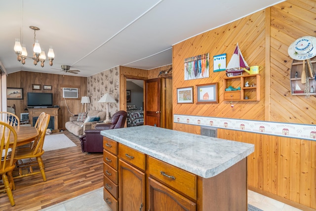 13506 Elmer Hanson Dr SE, Woodside Twp, MN 56736 - kitchen featuring an AC wall unit, wood walls, light countertops, a kitchen island, and ceiling fan