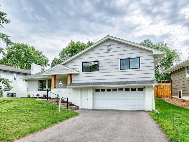 4909 Trillium Ln, Edina, MN 55435 - split level home featuring asphalt driveway, an attached garage, a chimney, and roof with shingles