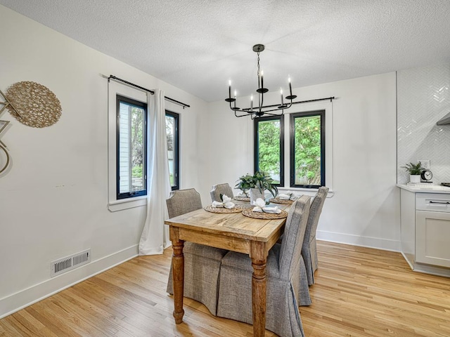 4909 Trillium Ln, Edina, MN 55435 - dining area with a chandelier, light wood-type flooring, and a textured ceiling