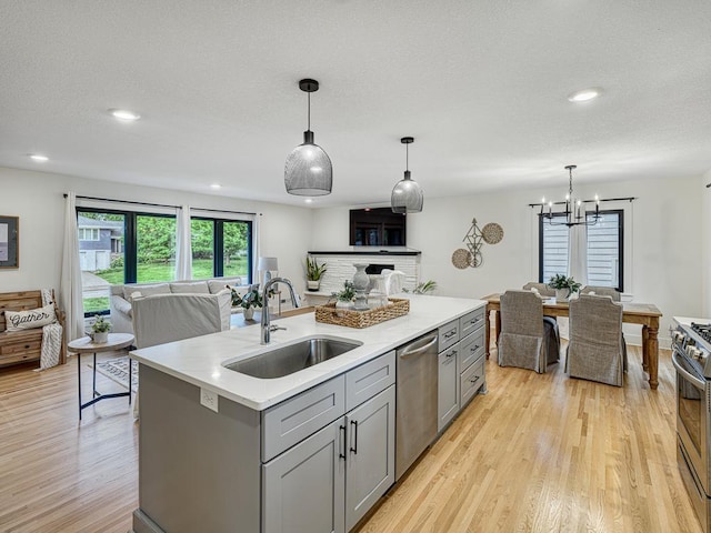 4909 Trillium Ln, Edina, MN 55435 - kitchen featuring appliances with stainless steel finishes, gray cabinetry, open floor plan, light wood-type flooring, and light countertops