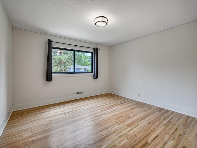 4909 Trillium Ln, Edina, MN 55435 - spare room featuring light wood-style flooring and a textured ceiling