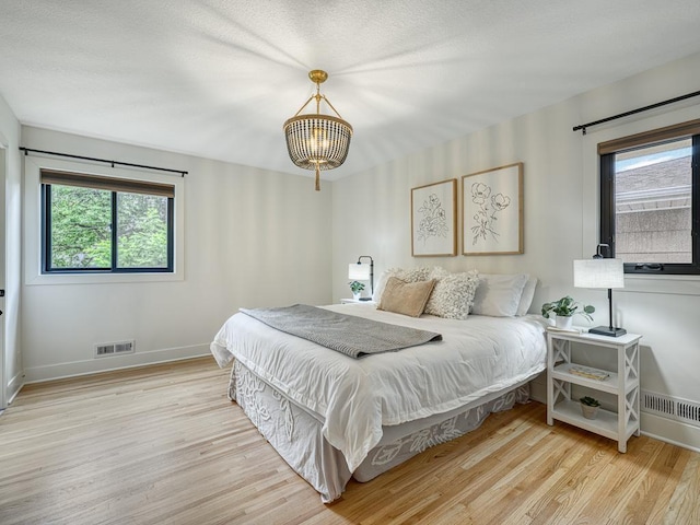4909 Trillium Ln, Edina, MN 55435 - bedroom with wood finished floors, multiple windows, and a chandelier