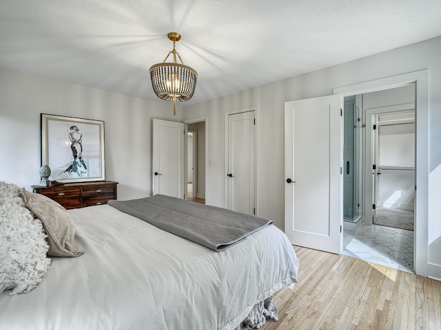 4909 Trillium Ln, Edina, MN 55435 - bedroom with light wood-style floors, a chandelier, and a closet