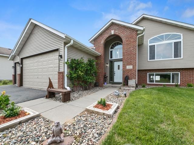 1813 Canton Rd, Prescott, WI 54021 - view of front of property with brick siding, a front lawn, driveway, and an attached garage