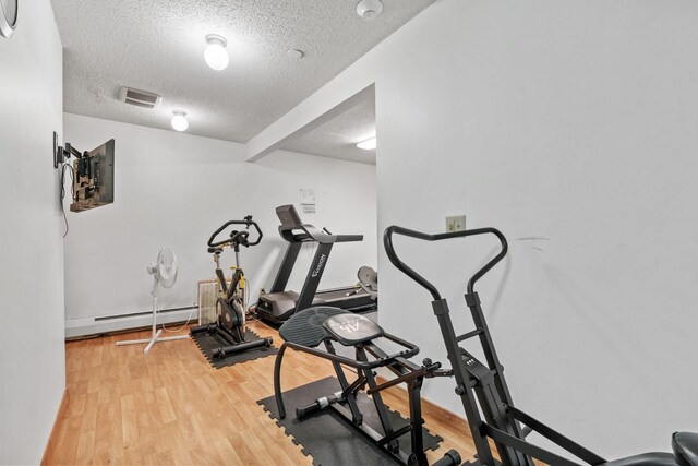 2801 Flag Ave N Unit 314, New Hope, MN 55427 - exercise area with a baseboard radiator, a textured ceiling, and light wood-style floors