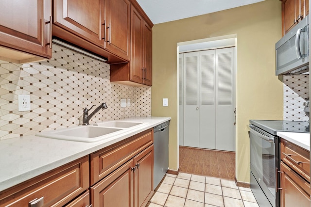 2801 Flag Ave N Unit 314, New Hope, MN 55427 - kitchen with appliances with stainless steel finishes, backsplash, light countertops, light tile patterned flooring, and brown cabinets