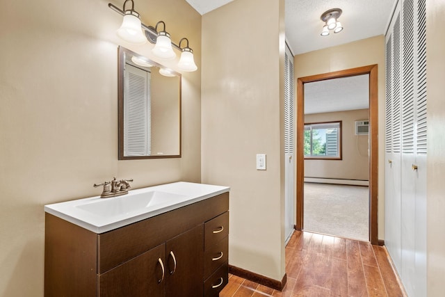 2801 Flag Ave N Unit 314, New Hope, MN 55427 - bathroom featuring baseboard heating, vanity, wood finished floors, and a wall unit AC