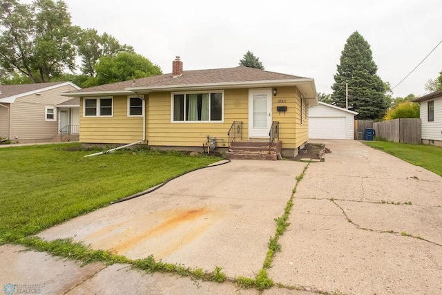 1820 5th St S, Moorhead, MN 56560 - view of front of house with a garage, a chimney, and an outbuilding