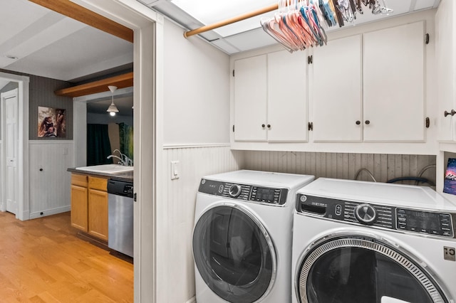 2606 Sessions St NW, Alexandria, MN 56308 - washroom with separate washer and dryer, light wood-style flooring, cabinet space, and a wainscoted wall