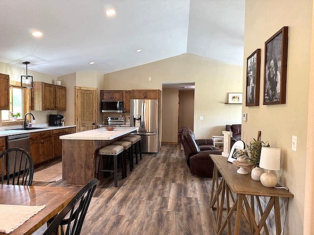 16696 Eclipse Dr, Park Rapids, MN 56470 - kitchen featuring appliances with stainless steel finishes, light countertops, lofted ceiling, a kitchen breakfast bar, and dark wood-style floors