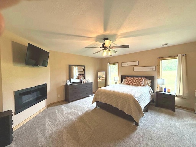 16696 Eclipse Dr, Park Rapids, MN 56470 - carpeted bedroom featuring multiple windows, a glass covered fireplace, and ceiling fan