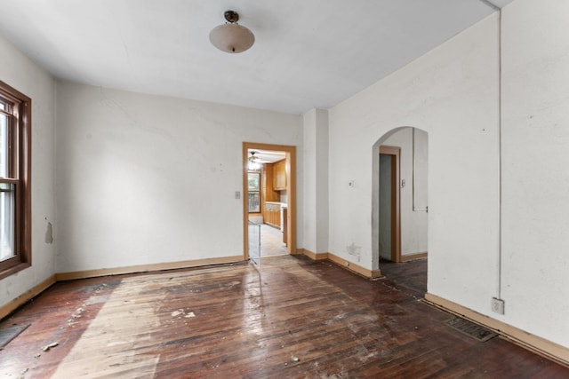 693 Bedford St, Saint Paul, MN 55130 - unfurnished room featuring arched walkways, plenty of natural light, and wood-type flooring