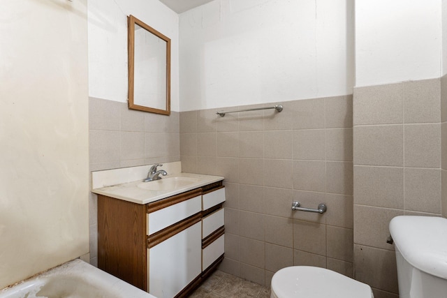 693 Bedford St, Saint Paul, MN 55130 - bathroom with tile walls, vanity, tile patterned floors, a tub to relax in, and a wainscoted wall