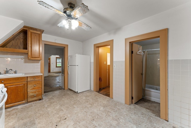 693 Bedford St, Saint Paul, MN 55130 - kitchen with freestanding refrigerator, a ceiling fan, light countertops, brown cabinets, and tile walls