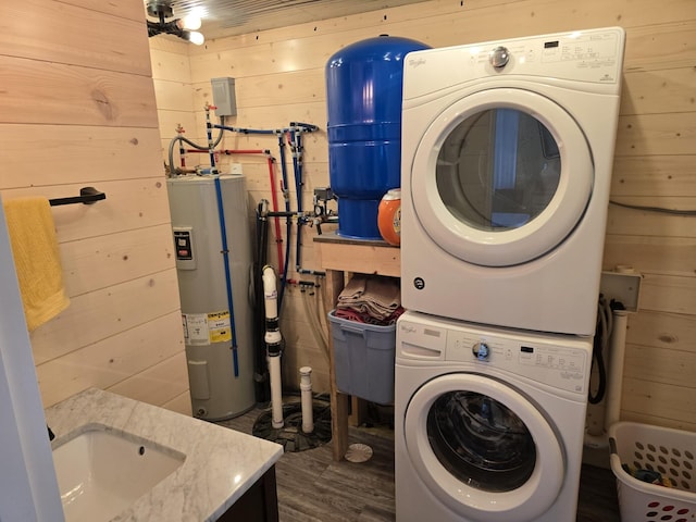 20389 640th Ln, Jacobson, MN 55752 - washroom with stacked washing machine and dryer, electric water heater, wooden walls, and dark wood-type flooring