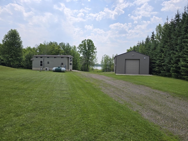 20389 640th Ln, Jacobson, MN 55752 - view of green lawn with dirt driveway, an outbuilding, and a detached garage