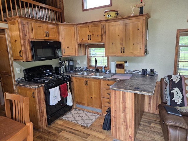 20389 640th Ln, Jacobson, MN 55752 - kitchen featuring black appliances, a peninsula, dark countertops, light wood-style flooring, and plenty of natural light