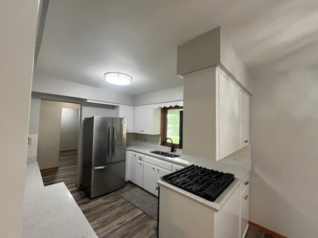 200 Amsterdam Ave E, Hollandale, MN 56045 - kitchen with freestanding refrigerator, black gas stovetop, dark wood-type flooring, and light countertops