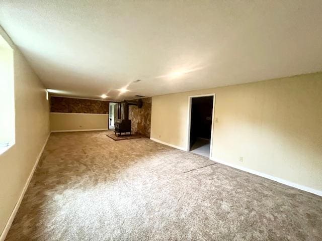 200 Amsterdam Ave E, Hollandale, MN 56045 - unfurnished living room with a wood stove and carpet floors