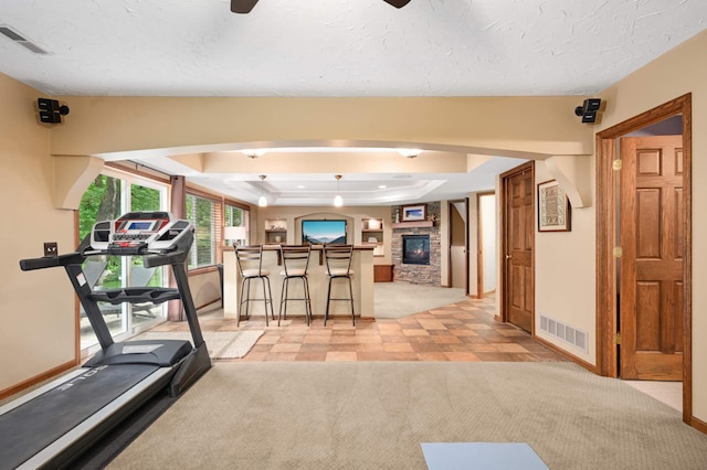 10787 Alison Way, Inver Grove Heights, MN 55077 - workout area featuring a raised ceiling, a ceiling fan, light carpet, and a fireplace