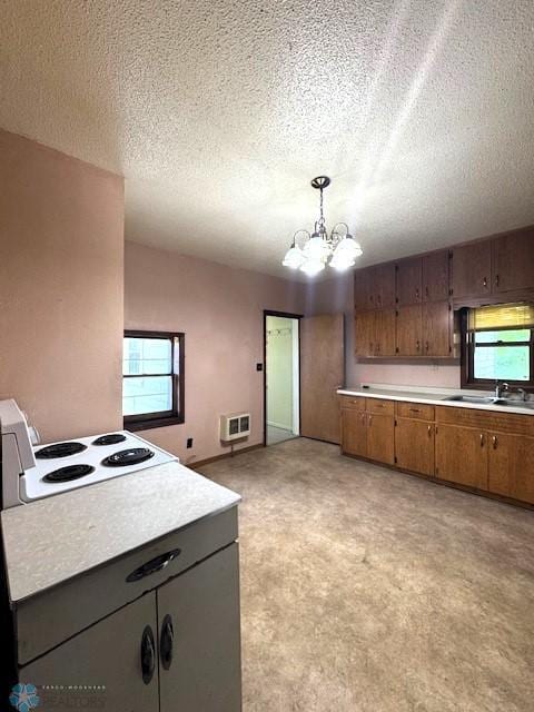 857 Main St, Mahnomen, MN 56557 - kitchen featuring light countertops, a chandelier, brown cabinetry, a textured ceiling, and heating unit