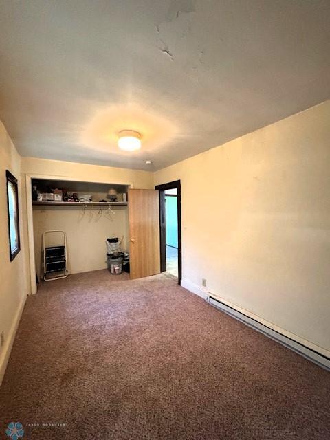 857 Main St, Mahnomen, MN 56557 - unfurnished living room with baseboard heating and carpet floors
