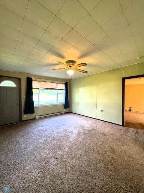 857 Main St, Mahnomen, MN 56557 - carpeted empty room featuring a baseboard heating unit and ceiling fan