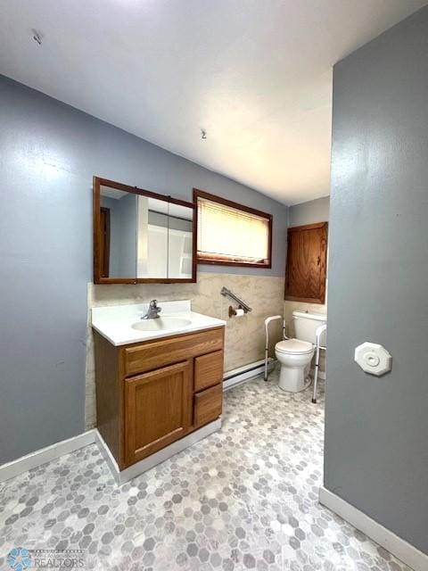857 Main St, Mahnomen, MN 56557 - half bathroom featuring a baseboard heating unit, vanity, and tile patterned floors