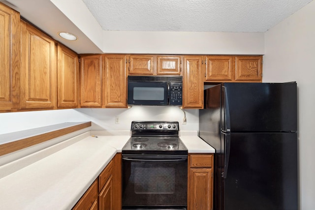 1369 Spencer Rd W, Saint Paul, MN 55108 - kitchen featuring black appliances, light countertops, brown cabinetry, and a textured ceiling