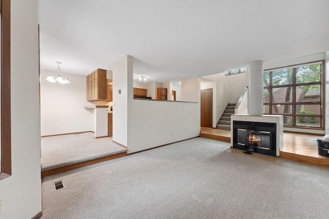 1369 Spencer Rd W, Saint Paul, MN 55108 - unfurnished living room featuring carpet, a chandelier, and stairway