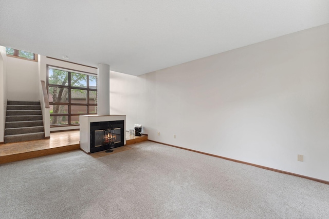 1369 Spencer Rd W, Saint Paul, MN 55108 - unfurnished living room with stairs, carpet floors, and a fireplace with flush hearth