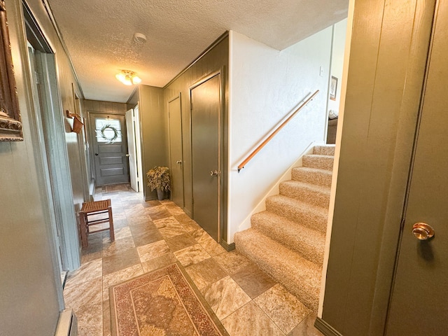 906 Whitford St, Fergus Falls, MN 56537 - entrance foyer with a textured ceiling, stairs, light stone finish floors, and wood walls