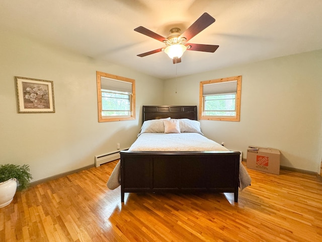 906 Whitford St, Fergus Falls, MN 56537 - bedroom with multiple windows, a baseboard radiator, light wood-style floors, and a ceiling fan