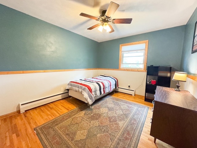 906 Whitford St, Fergus Falls, MN 56537 - bedroom featuring a baseboard radiator, wood finished floors, and ceiling fan