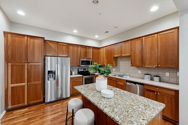 5900 Oxford St Unit 8, Saint Louis Park, MN 55416 - kitchen with stainless steel appliances, brown cabinetry, light wood-type flooring, tasteful backsplash, and recessed lighting