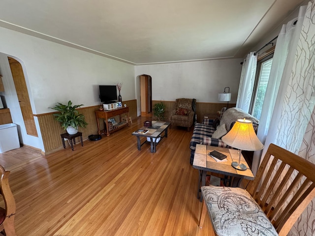 106 Oak Ave, Ottertail, MN 56571 - living area with arched walkways, a wainscoted wall, light wood-type flooring, and wood walls