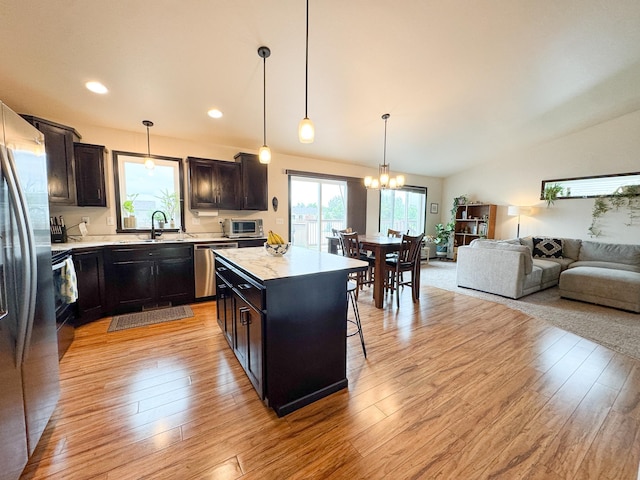 4551 15th St S, Moorhead, MN 56560 - kitchen with stainless steel appliances, a chandelier, open floor plan, vaulted ceiling, and light countertops