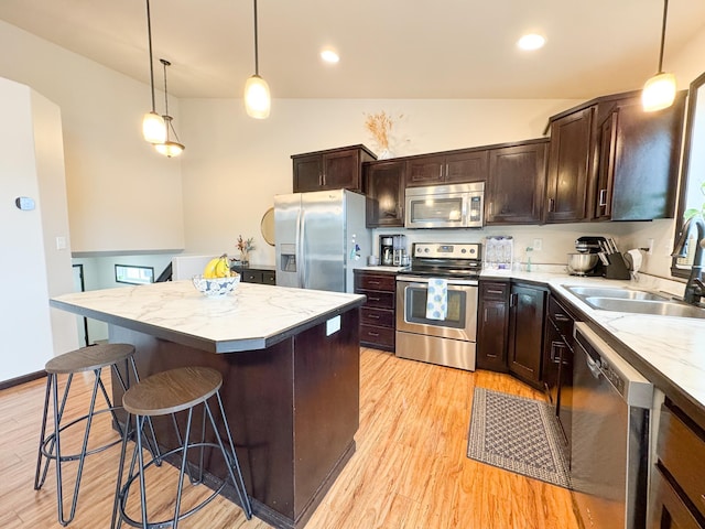 4551 15th St S, Moorhead, MN 56560 - kitchen with appliances with stainless steel finishes, a center island, light wood-style floors, dark brown cabinets, and lofted ceiling