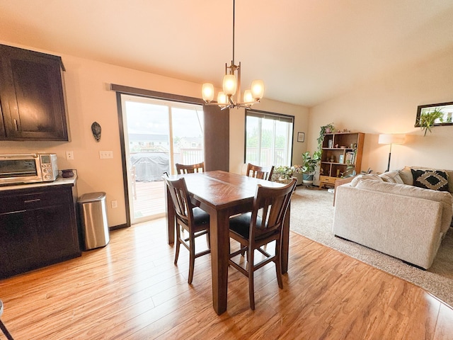 4551 15th St S, Moorhead, MN 56560 - dining space featuring a chandelier, light wood-style flooring, and vaulted ceiling