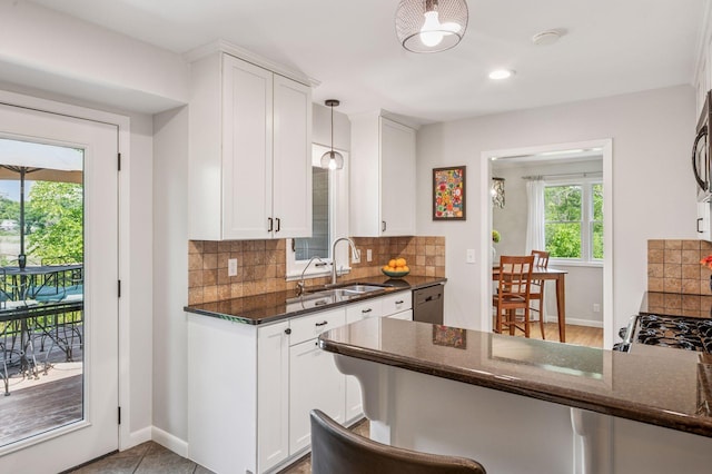 4428 Marlborough Ct, Minnetonka, MN 55345 - kitchen featuring dark stone counters, white cabinetry, tasteful backsplash, dishwasher, and decorative light fixtures